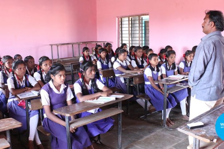 A teacher stands in front of a class of children