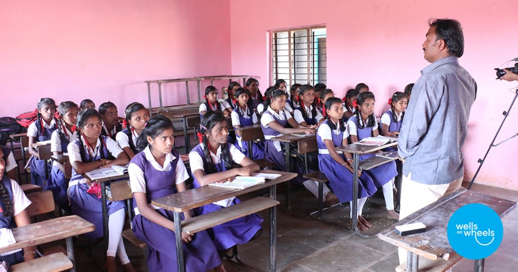 A teacher stands in front of a class of children